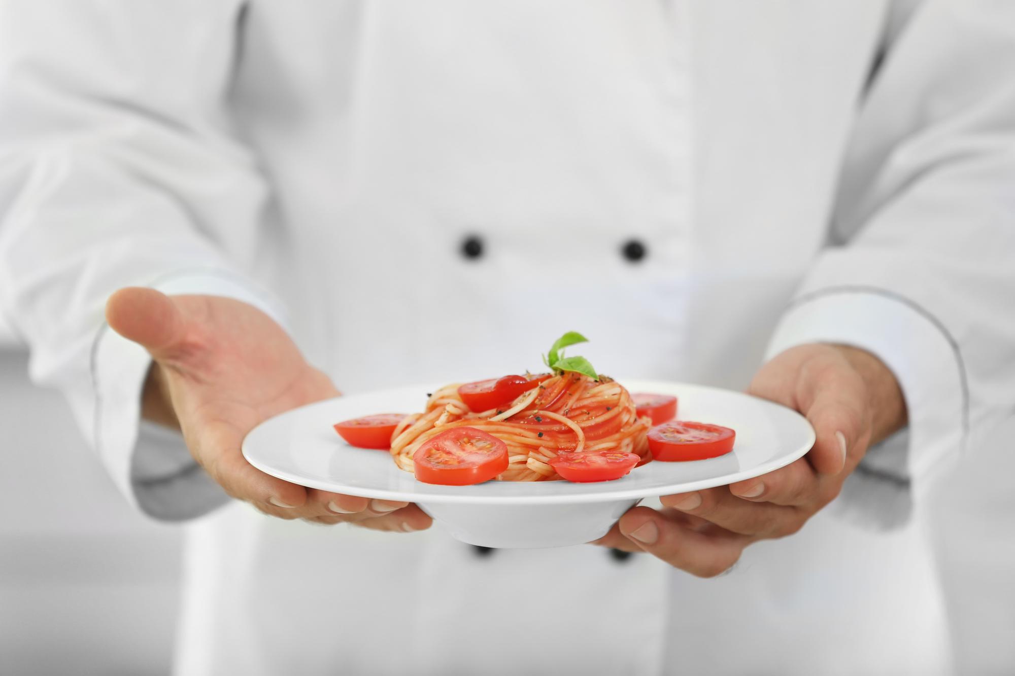 Chef preparing plated dish in modern kitchen